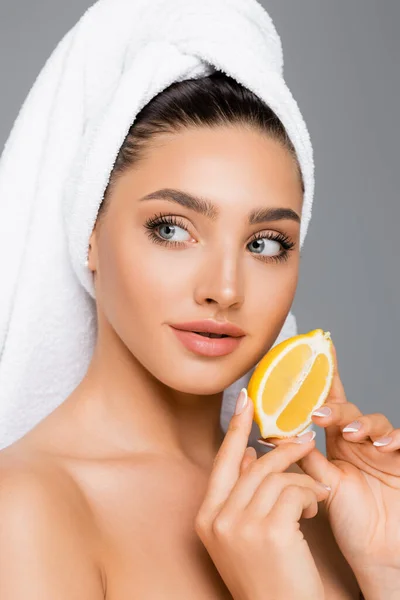 Mujer con toalla en la cabeza y limón aislado en gris — Stock Photo