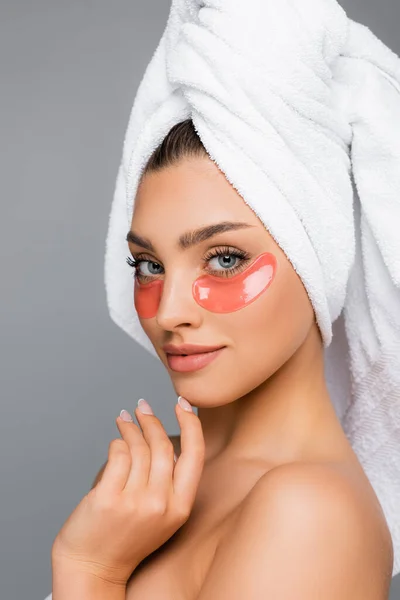 Mujer con toalla en la cabeza y parches oculares aislados en gris - foto de stock