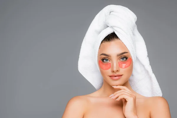 Woman with towel on head and eye patches isolated on grey — Stock Photo