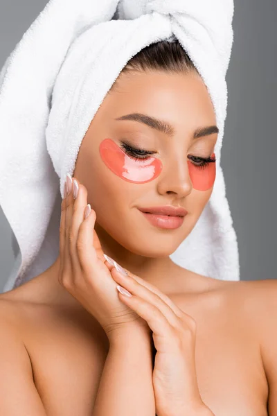 Mujer con toalla en la cabeza y parches oculares aislados en gris - foto de stock