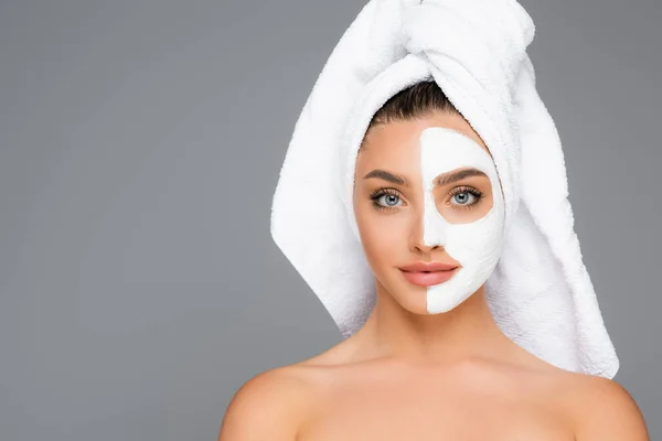 Femme avec serviette sur la tête et masque en argile sur le visage isolé sur gris — Photo de stock