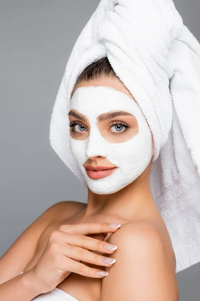 Femme avec serviette sur la tête et masque en argile sur le visage isolé sur gris — Photo de stock