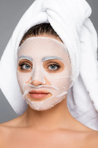 Mujer con toalla en la cabeza y mascarilla en la cara aislada en gris - foto de stock