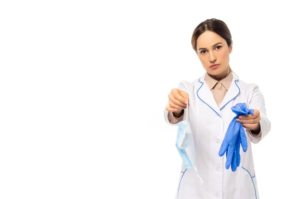 Médecin en manteau blanc montrant masque médial et gants en latex isolés sur blanc — Photo de stock