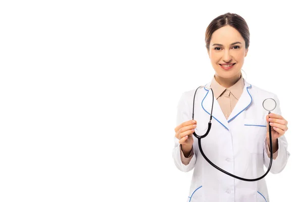 Médico sonriente de bata blanca sosteniendo estetoscopio aislado en blanco — Stock Photo