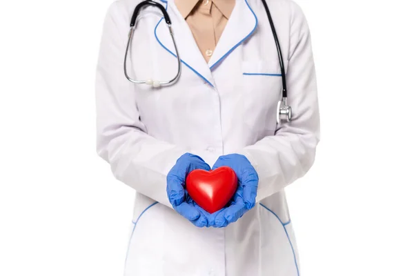 Vista recortada del médico sosteniendo el corazón rojo aislado en blanco - foto de stock