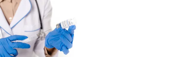 Панорамний знімок лікаря в латексних рукавичках, що тримає шприц і банку з вакциною ізольовані на білому — стокове фото