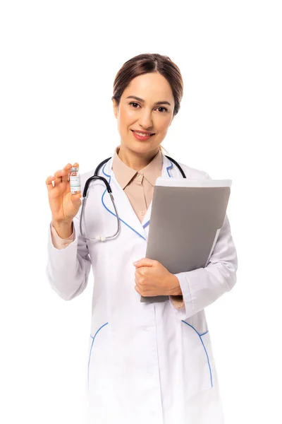Médico sonriente sosteniendo frasco de vacuna y carpeta de papel aislado en blanco - foto de stock