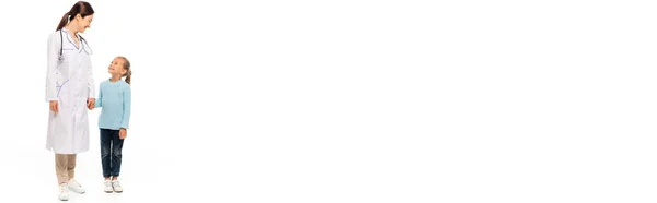 Panoramic crop of pediatrist smiling and holding hand of girl on white background — Stock Photo