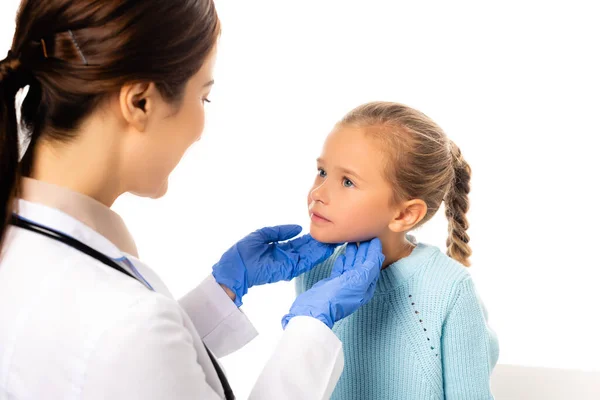 Enfoque selectivo del pediatra en guantes de látex tocando cuello de niña aislada en blanco — Stock Photo