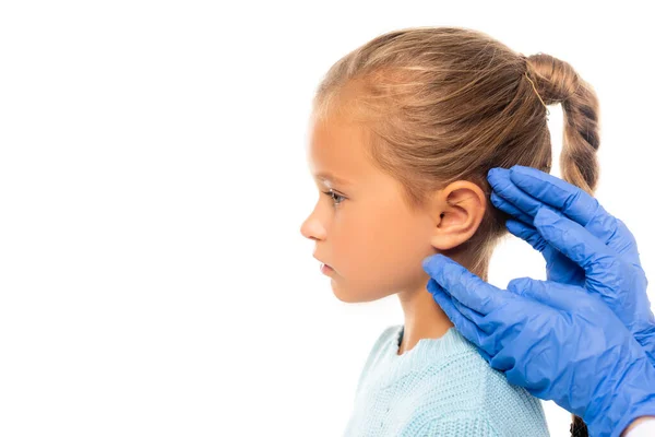 Pediatra em luvas de látex tocando orelha de menina isolada em branco — Fotografia de Stock