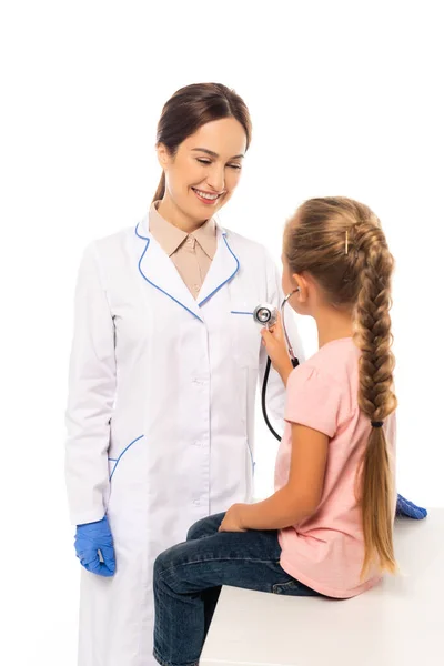Foco seletivo da criança segurando estetoscópio perto do médico sorridente isolado no branco — Fotografia de Stock