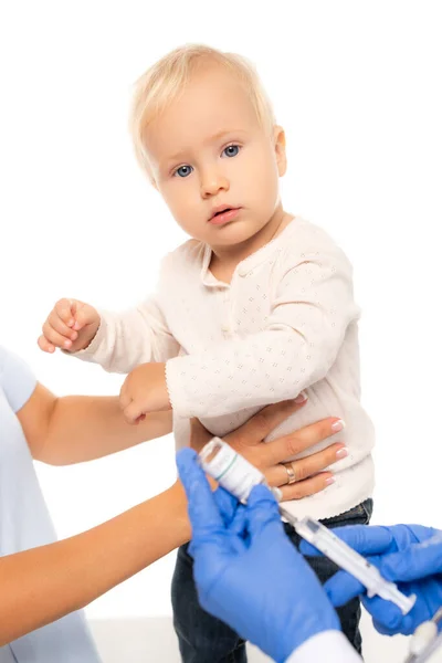 Selective focus of toddler boy looking at camera near father and doctor with syringe and vaccine isolated on white — Stock Photo