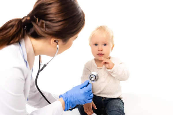 Selektive Fokussierung des Kleinkindes auf Kamera in der Nähe des Kinderarztes mit Stethoskop isoliert auf weiß — Stockfoto