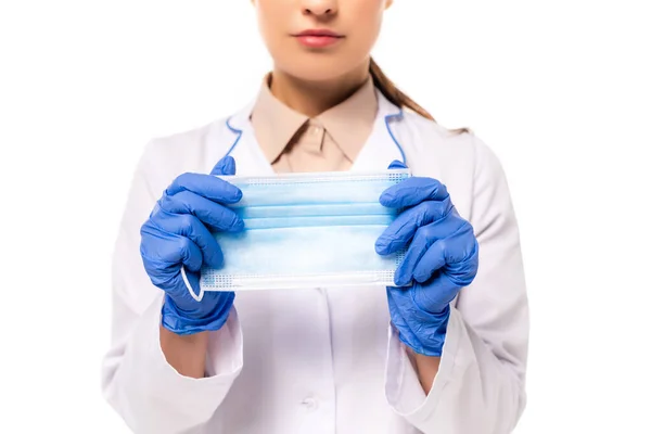 Vista cortada do médico segurando máscara médica isolada em branco — Fotografia de Stock