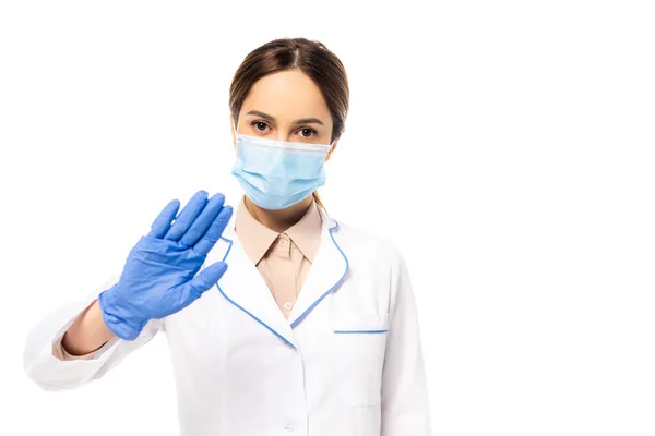 Médico en máscara médica y guante de látex mostrando gesto de stop aislado en blanco - foto de stock