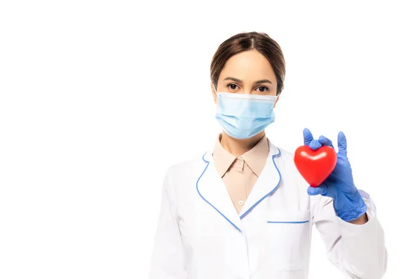Médico em máscara médica e luva de látex mostrando coração isolado em branco — Fotografia de Stock