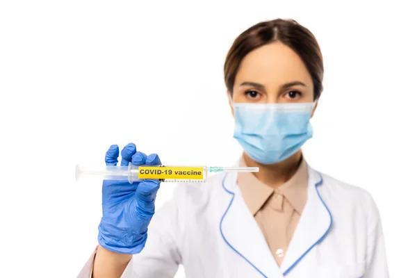 Selektiver Fokus des Arztes in medizinischer Maske und Latexhandschuhhalterspritze mit Covid-19-Impfstoff isoliert auf weiß — Stockfoto