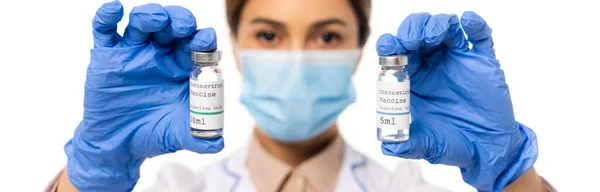 Cabeçalho do site do médico segurando frascos com letras da vacina coronavírus isolado no branco — Fotografia de Stock