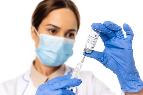 Enfoque selectivo del médico en guantes de látex recogiendo la vacuna contra el coronavirus en jeringa aislada en blanco - foto de stock