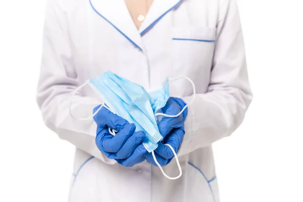 Vue recadrée du médecin dans des gants en latex tenant des masques médicaux isolés sur blanc — Photo de stock