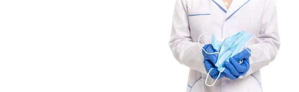 Panoramaorientierung des Arztes, der medizinische Masken isoliert auf Weiß hält — Stockfoto