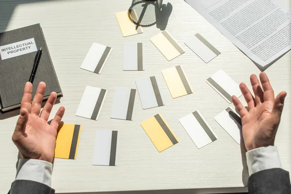 Ausgeschnittene Ansicht von Geschäftsleuten Hände in der Nähe von Kreditkarten auf weißem strukturierten Hintergrund — Stockfoto