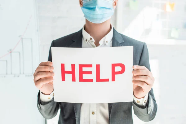 Cropped view of man holding sign with help lettering on blurred background — Stock Photo