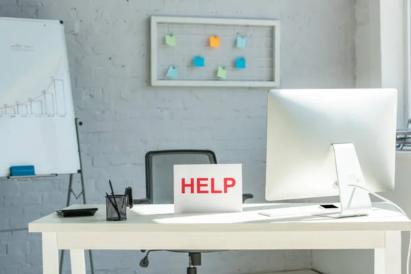 Interior of modern workplace and sign with help lettering — Stock Photo