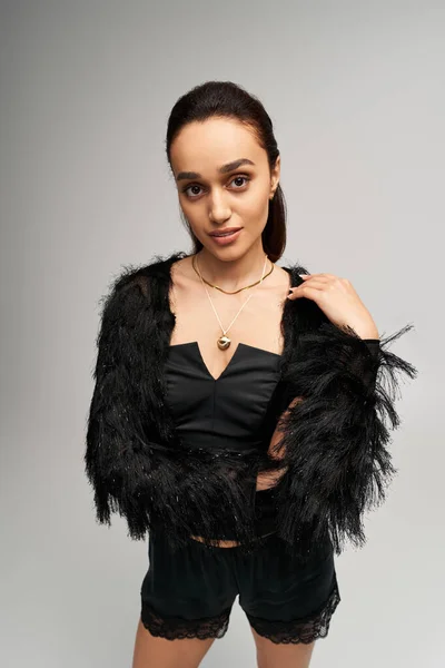 Fashion-forward jeune femme présente un corset noir tendance avec une couche extérieure élégante en studio. — Photo de stock