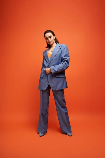 Стильная молодая женщина уверенно позирует в шикарном синем костюме, источая современные модные флюиды. — стоковое фото