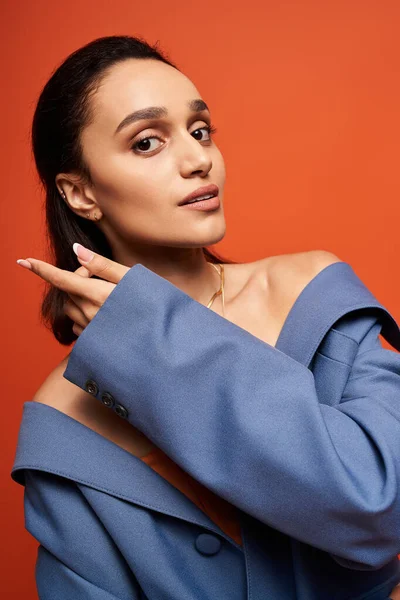 Уверенная молодая женщина демонстрирует свой модный наряд в синем костюме в студии. — стоковое фото