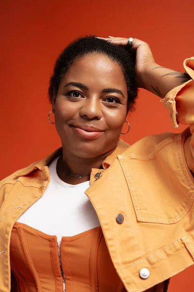 Mujer confiada en un elegante traje de otoño posa sobre un fondo vibrante. - foto de stock
