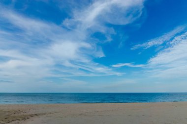 Kimse mavi gökyüzü ve bulutlar yaz sezonu ile sahilde.