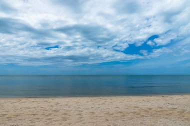 Kimse mavi gökyüzü ve bulutlar yaz sezonu ile sahilde.