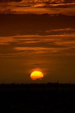 Siluet zemin büyük günbatımı gökyüzü ve koyu turuncu bulutlar ile