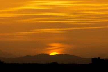 Büyük güneş ile Sunset Gökyüzü silueti manzara dağın arkasında düşüyor. Tayland seyahat.