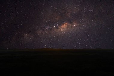 Samanyolu ve stardust yukarıda siyah dağ ile gece gökyüzü.
