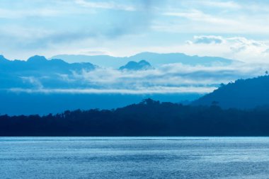 Yukarıda Sangkhla Buri. bölgede, Kanchanaburi sabah dağ mavi bulut ile göl manzarası. Western Tayland seyahat.