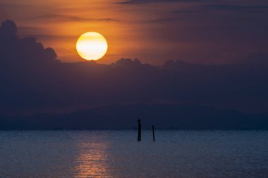 Bulanıklık saat içinde göle siluet bulut ile büyük günbatımı.