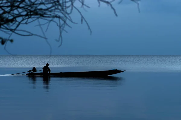 湖の青時間の最小限の釣りボートのシルエット — ストック写真