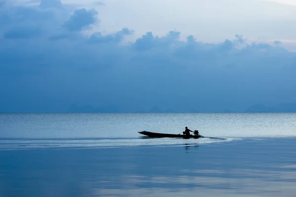 湖の青時間の最小限の釣りボートのシルエット — ストック写真