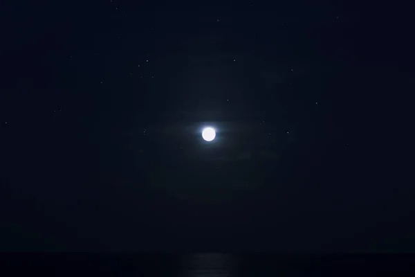 海の上の星と暗い青い夜の満月 — ストック写真