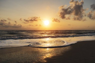 yumuşak dalga ile sahilde gündoğumu.