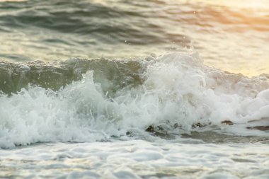 Güneş ışığı ile sahilde yumuşak dalga.