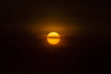 Gün batımı gökyüzünde yumuşak bulut ile büyük güneş.