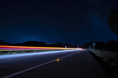 Karanlık gece yolda arabanın hareket ışığı.