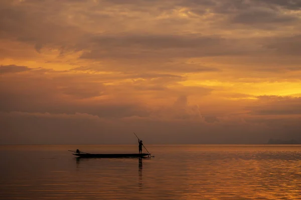 Alacakaranlık gökyüzü ile gölde minimal siluet balıkçı. — Stok fotoğraf