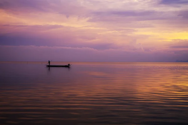 Pescador de silueta mínima en el lago con cielo crepuscular . —  Fotos de Stock