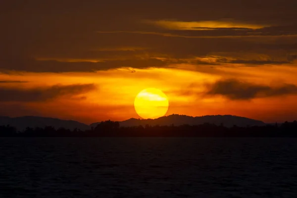 Solnedgång med Silhouette Mountain och sjön. — Stockfoto